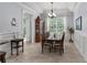 Elegant dining room with hardwood table, chandelier, wainscotting, and large window with natural light at 341 Bahama Dr., Murrells Inlet, SC 29576