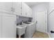 Bright laundry room with white cabinets, sink, washer, and dryer at 341 Bahama Dr., Murrells Inlet, SC 29576