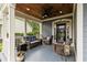 Inviting covered front porch with wood ceiling, comfortable seating, and decorative plants at 341 Bahama Dr., Murrells Inlet, SC 29576
