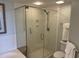 Glass-enclosed shower with wall-mounted shower head and a small seat at 371 S Dunes Dr., Pawleys Island, SC 29585