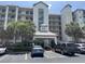 Elegant multi-story building with lush landscaping, covered entrance, and ample parking space at 371 S Dunes Dr., Pawleys Island, SC 29585