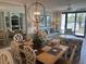 Cozy dining area flows into the living room, featuring large windows and a decorative chandelier at 371 S Dunes Dr., Pawleys Island, SC 29585