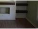 Minimalist living room featuring hardwood floors, fresh white walls and built-in dark wood shelving at 3909 Mallard Circle, Myrtle Beach, SC 29579