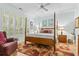 Charming bedroom with a four-poster bed, light blue walls, and large window with shutters at 405 Pipers Ln. # 405, Myrtle Beach, SC 29575