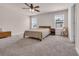 Bright bedroom with neutral walls and carpet has bed, windows, ceiling fan, and furnishings at 4115 Bayhill St., Myrtle Beach, SC 29579