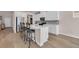 Modern kitchen with white cabinetry, stainless steel appliances, and a sleek island with bar seating at 4115 Bayhill St., Myrtle Beach, SC 29579