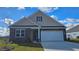Charming single-Gathering home showcasing stone accents, a two-car garage and well-manicured lawn at 446 Clear Lake Dr., Conway, SC 29526