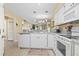 Modern kitchen with white appliances and cabinets and an open view to the dining area at 45 Pinehurst Ln. # 2C, Pawleys Island, SC 29585