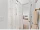 Bathroom with shower stall behind a decorative curtain and a glimpse into an adjacent bedroom at 4687 Wild Iris Dr. # 303, Myrtle Beach, SC 29577