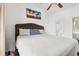 Bright bedroom featuring a queen bed with a tufted headboard and ensuite bath access at 4687 Wild Iris Dr. # 303, Myrtle Beach, SC 29577