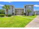 Condo building featuring three stories, private balconies, and a well-manicured lawn with walking path at 4687 Wild Iris Dr. # 303, Myrtle Beach, SC 29577