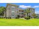 Close up of condo building featuring private balconies, lush green lawns, and colorful landscaping at 4687 Wild Iris Dr. # 303, Myrtle Beach, SC 29577