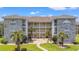 Charming condo complex featuring stone accents, lush landscaping, and sunny skies at 4687 Wild Iris Dr. # 303, Myrtle Beach, SC 29577