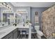 Bathroom vanity featuring double mirrors and sinks with a chair and decorated shower at 5040 Windsor Green Way # 204, Myrtle Beach, SC 29579
