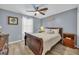 Bedroom with wood floors, a ceiling fan, and a white comforter on the bed at 5040 Windsor Green Way # 204, Myrtle Beach, SC 29579