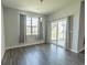 Bright living room with a sliding glass door, wood flooring and neutral tones at 506 Hogwart Ln., Longs, SC 29568