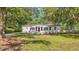 Inviting home featuring well-maintained lawn, mature trees, light exterior, and black shutters at 5074 Cowart Ct., Murrells Inlet, SC 29576