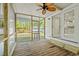 Screened-in porch with a ceiling fan and wood flooring leading to a back yard at 5074 Cowart Ct., Murrells Inlet, SC 29576