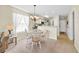 Bright dining area with a round wooden table and white chairs, next to a modern kitchen at 556 White River Dr. # 44F, Myrtle Beach, SC 29579