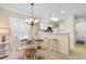 Charming dining area features a round table, white chairs, and a view of the modern kitchen at 556 White River Dr. # 44F, Myrtle Beach, SC 29579