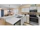 Bright kitchen with stainless steel appliances, breakfast bar, and open view to living area at 556 White River Dr. # 44F, Myrtle Beach, SC 29579