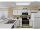 Bright kitchen with stainless appliances, white cabinets, and white countertops at 556 White River Dr. # 44F, Myrtle Beach, SC 29579