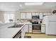 Bright kitchen with white cabinets, white countertops, and stainless appliances at 556 White River Dr. # 44F, Myrtle Beach, SC 29579