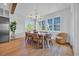 Dining room boasts large windows, hardwood floors, and a stylish chandelier, creating an elegant ambiance at 573 S Dunes Dr., Pawleys Island, SC 29585