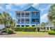 Charming blue two-story home with double balconies and a beautifully landscaped front yard at 573 S Dunes Dr., Pawleys Island, SC 29585