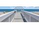 Walkway with a gate leading to the beach and beautiful blue ocean at 573 S Dunes Dr., Pawleys Island, SC 29585