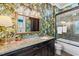 Stylish bathroom with leaf wallpaper, a shower over tub, a granite countertop and a decorative mirror at 58 Swan Point Trail, Georgetown, SC 29440