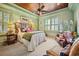 Relaxing bedroom with green walls, shuttered windows, and a comfortable upholstered bed with patterned pillows at 58 Swan Point Trail, Georgetown, SC 29440