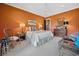 Bedroom with warm orange walls, carpeted floors, traditional furniture, and art that add to the room's style at 58 Swan Point Trail, Georgetown, SC 29440