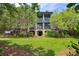 Charming home exterior with brick base, screened porches, well manicured lawn and mature trees at 58 Swan Point Trail, Georgetown, SC 29440