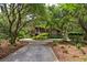 Stunning exterior view of home featuring lush landscaping and mature trees along a winding driveway at 58 Swan Point Trail, Georgetown, SC 29440