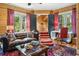 Comfortable living room with wood paneled walls, red accents and leather furniture at 58 Swan Point Trail, Georgetown, SC 29440