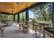 Outdoor screened porch featuring ping pong table, comfortable wicker chair, bar table and water view at 58 Swan Point Trail, Georgetown, SC 29440