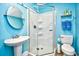 Vibrant blue bathroom featuring a pedestal sink, toilet, and glass-enclosed shower at 6095 Catalina Dr. # 714, North Myrtle Beach, SC 29582