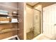 Modern bathroom featuring a glass-enclosed shower with brown tiled flooring and shelving for towel storage at 6095 Catalina Dr. # 714, North Myrtle Beach, SC 29582