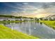 Scenic pond view featuring lush landscaping, fountain, and residential homes in the background at 6095 Catalina Dr. # 714, North Myrtle Beach, SC 29582