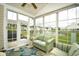 Bright sunroom features large windows and comfortable striped sofas overlooking a pond with fountain at 6095 Catalina Dr. # 714, North Myrtle Beach, SC 29582