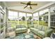 Bright sunroom features large windows, ceiling fan, and comfortable striped sofas overlooking a pond at 6095 Catalina Dr. # 714, North Myrtle Beach, SC 29582