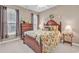 Bedroom features a wooden bed frame, floral bedding, a ceiling fan, and natural light from the window at 6434 Longwood Dr., Murrells Inlet, SC 29576