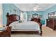 Stylish main bedroom with a dark wood bed frame, dresser, and calm aqua walls at 6434 Longwood Dr., Murrells Inlet, SC 29576