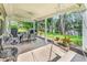 Covered outdoor patio with dining furniture, a swing, and a view of the lake surrounded by trees at 6434 Longwood Dr., Murrells Inlet, SC 29576