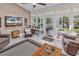 Inviting sunroom with tile floors, large windows overlooking a scenic view and cozy seating at 6434 Longwood Dr., Murrells Inlet, SC 29576