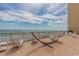 Oceanfront deck with a hammock and white lounge chairs with blue sky background at 6900 N Ocean Blvd. # 840, Myrtle Beach, SC 29572