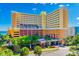 Beautiful multi-story hotel with manicured landscaping, vibrant flowers, and lush green trees at 6900 N Ocean Blvd. # 840, Myrtle Beach, SC 29572