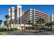 Exterior of a modern multi-story building with a parking garage and palm trees at 7200 N Ocean Blvd. # 222, Myrtle Beach, SC 29572