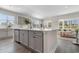 Bright open kitchen featuring an island with light gray cabinets, quartz countertops and a view into the living area at 725 Doonbeg Ct., Conway, SC 29526